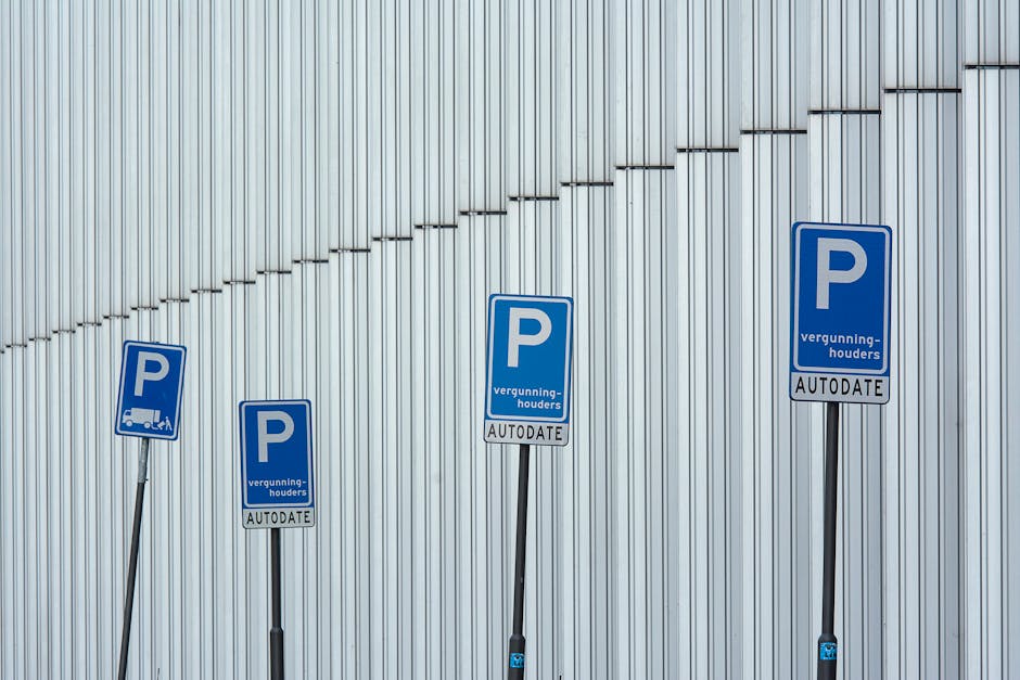 An underground parking area featuring an entrance to a building with brick walls on either side, illuminated by artificial lighting. In the foreground, a parking permit sign is mounted on a black pole